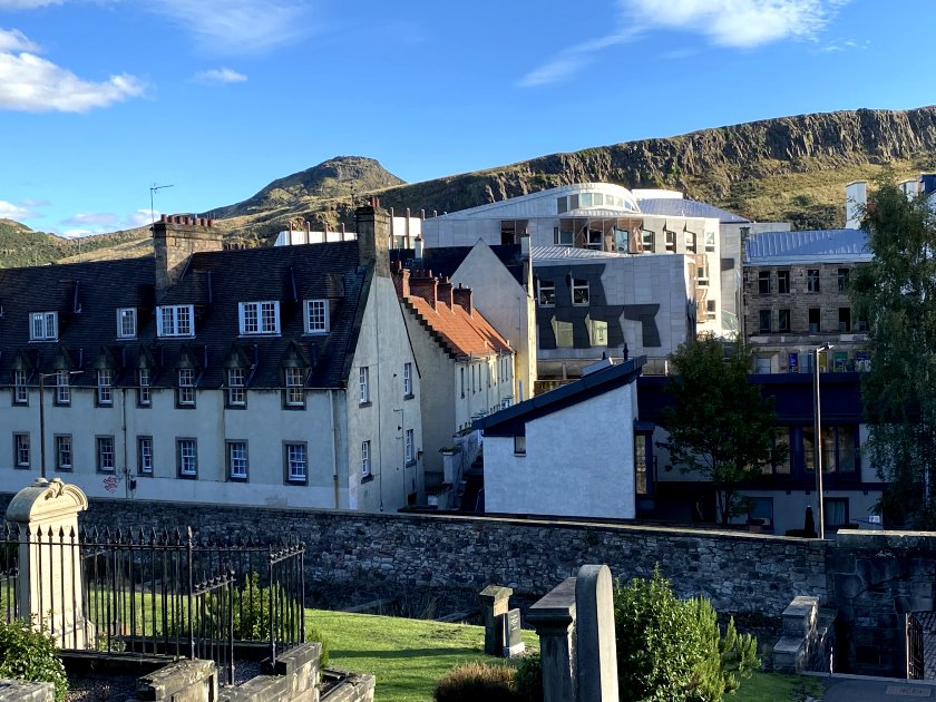 The Scottish Parliament sits in front of the Salisbury Crags
